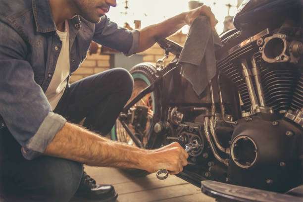 Attractive man is repairing a motorcycle in the repair shop