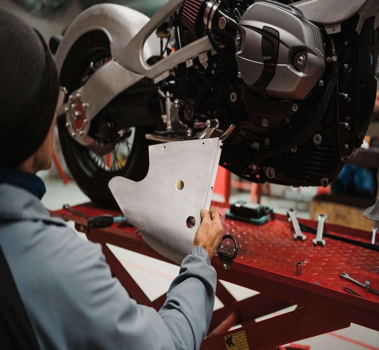 Repairman repair motorcycle, maintenance in garage. Mechanic fixing bike in a modern shop